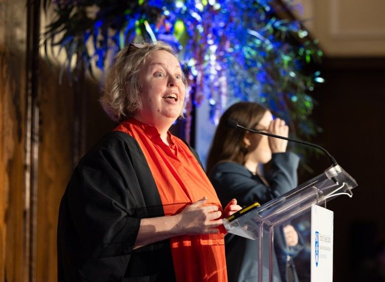 Woman at podium with colourful backdrop