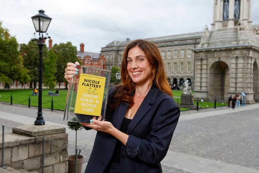 Picture of a woman holding a book in an exterior location