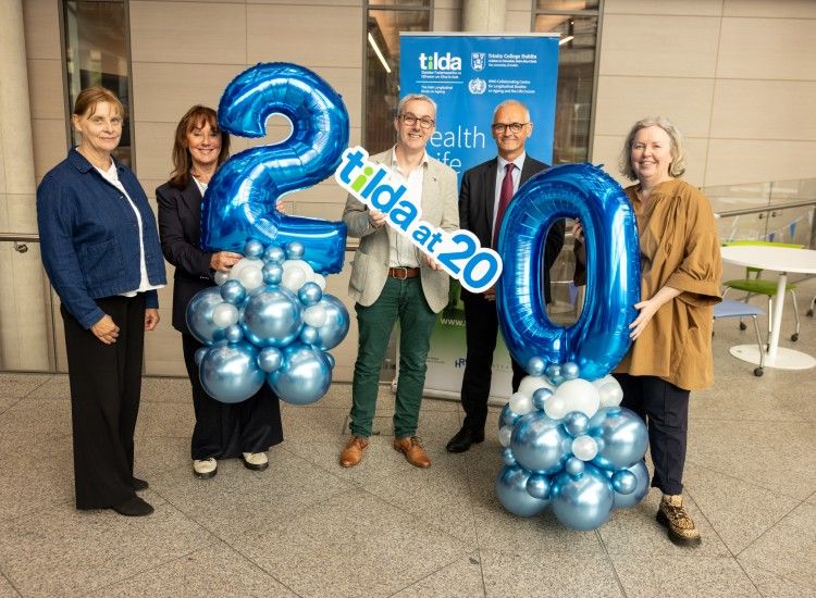 Group of people with 20th birthday balloons
