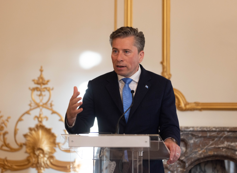 Tom Fletcher stands at podium