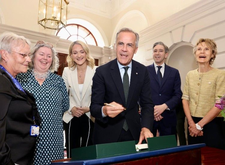 Five people pictured in a formal setting