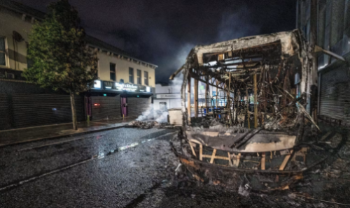 Burnt out bus pictured in a Belfast street at night