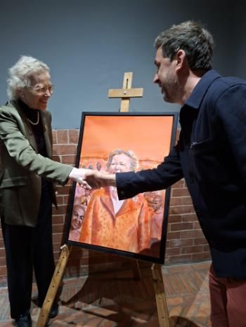 Mary Robinson shakes hands with Dr Browne in front of her portrait at the graduation ceremony