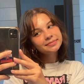Student with brown hair smiling taking a selfie