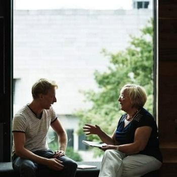 Two people speaking in a window seat of the Library in Trinity College Dublin