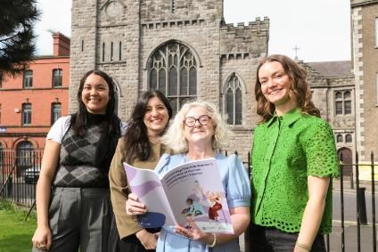 4 people holding a research project document