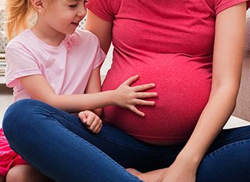 Mother with child touching pregnant stomach