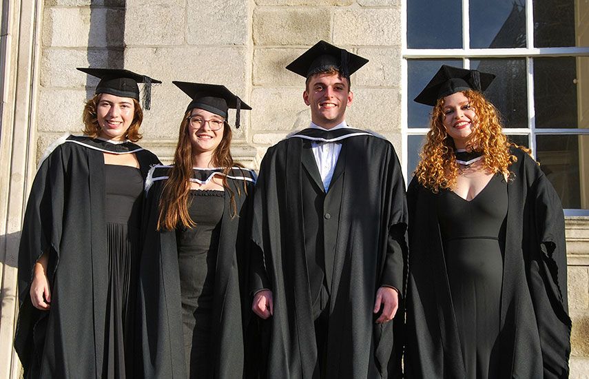 Group of 4 graduates in cap and gown