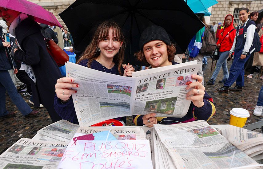 Students holding a copy of Trinity news