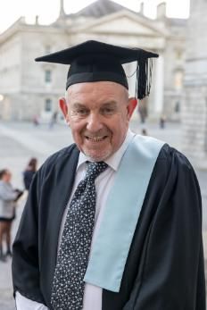 Older man smiling in graduation cap and gown